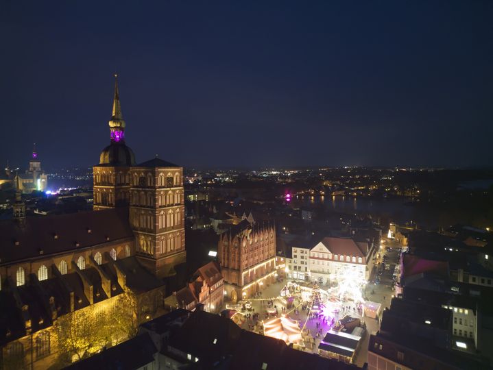 Der Stralsunder Weihnachtsmarkt, aufgenommen aus der Luft, vor der historischen Kulisse des Stralsunder Rathauses